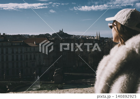 Scenic urban view of marseille with woman in winter outfit gazing from rooftop terrace 140892925