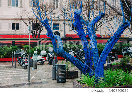 Striking urban scene with blue painted tree and motorbikes in cityscape 140893023