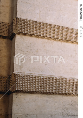 Textured stone wall with geometric patterns in urban architecture Textured stone wall with geometric patterns in urban architecture 140893076
