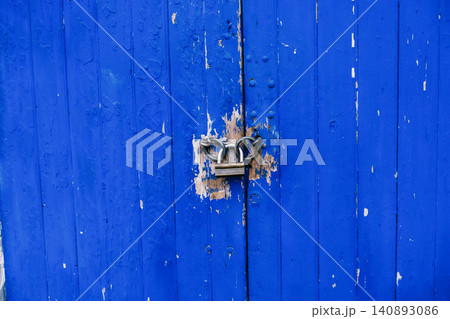 Rustic blue wooden door with lock and chain for security and texture 140893086
