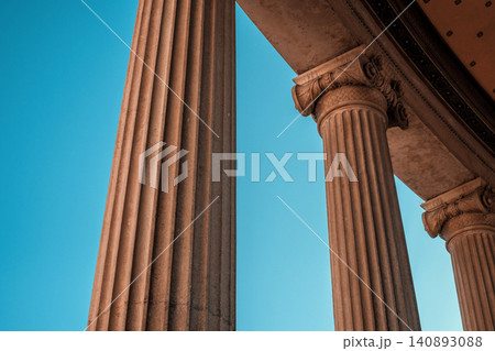 Majestic architectural pillars against clear blue sky in a historic setting Majestic architectural pillars against clear blue sky in a historic setting 140893088