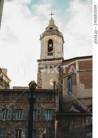 Historical church tower with weathered stone walls and elegant architecture under cloudy sky Historical church tower with weathered stone walls and elegant architecture under cloudy sky 140893094