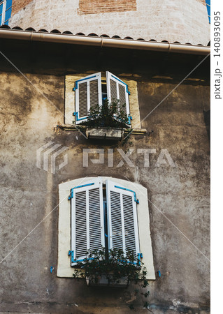 Rustic building with blue shutters and ivy in urban setting Rustic building with blue shutters and ivy in urban setting 140893095