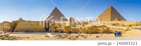 Giza, Egypt - Mar 11, 2023, a panorama of Great pyramids of Giza, and Sphinx, with some tourists on foreground, at daytime, Giza, Egypt Giza, Egypt - Mar 11, 2023, a panorama of Great pyramids of Giza, and Sphinx, with some tourists on foreground, at daytime, Giza, Egypt 140893321