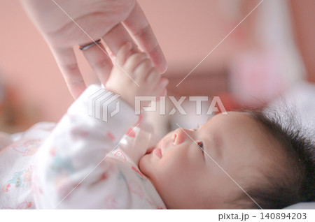 親の指をつかむ赤ちゃんの手元 親の指をつかむ赤ちゃんの手元 140894203