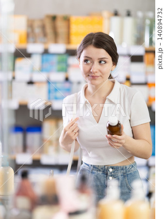 Female customer choosing cough syrup at pharmacy Female customer choosing cough syrup at pharmacy 140894732