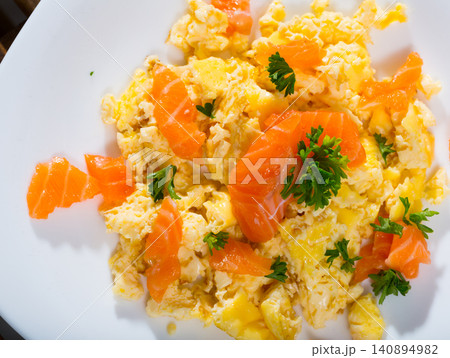 Tasty cooked omlette fried with salmon served at plate on table Tasty cooked omlette fried with salmon served at plate on table 140894982