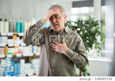 Senior man visits pharmacy and suffers from headache Senior man visits pharmacy and suffers from headache 140895150
