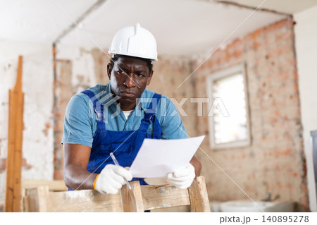Portrait of man builder with project documentation Portrait of man builder with project documentation 140895278