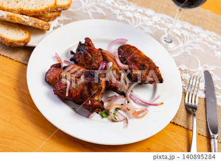 Appetizing spicy lamb shashlik with fresh onion and greens served with sauces. Traditional Caucasian cuisine Appetizing spicy lamb shashlik with fresh onion and greens served with sauces. Traditional Caucasian cuisine 140895284