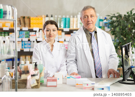 Portrait of two positive pharmacists in modern drugstore Portrait of two positive pharmacists in modern drugstore 140895403