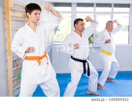 Young guy trains karate techniques in studio Young guy trains karate techniques in studio 140895452