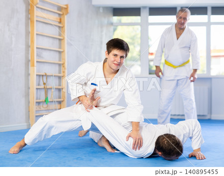 Adult and young men training judo fight 140895455
