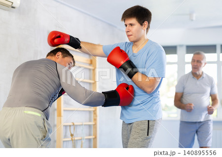Two men training boxing fight in studio Two men training boxing fight in studio 140895556