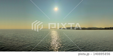 太陽の光が海面に映り込む穏やかな海と海岸線の風景 太陽の光が海面に映り込む穏やかな海と海岸線の風景 140895856