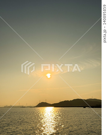 夕日に照らされる穏やかな海と山並みのシルエット風景 夕日に照らされる穏やかな海と山並みのシルエット風景 140895859