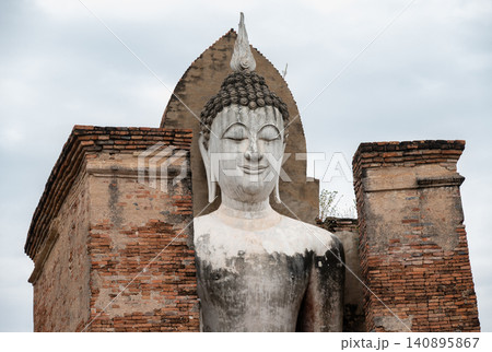 An old standing Buddha statue in Wat Mahathat temple the most important and impressive temple compound in Sukhothai Historical Park. An old standing Buddha statue in Wat Mahathat temple the most important and impressive temple compound in Sukhothai Historical Park. 140895867