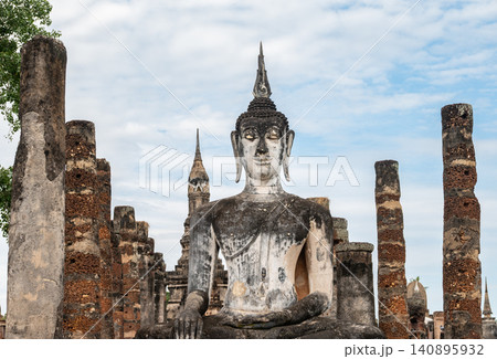 An old Buddha statue seated in Wat Mahathat temple the most important and impressive temple compound in Sukhothai Historical Park. An old Buddha statue seated in Wat Mahathat temple the most important and impressive temple compound in Sukhothai Historical Park. 140895932