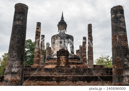 Rear view of old Buddha statue seated in Wat Mahathat temple the most important and impressive temple compound in Sukhothai Historical Park. 140896000