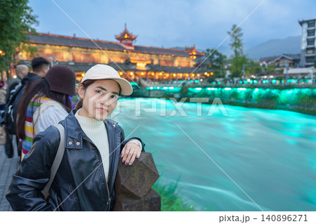 Happy woman traveler travel in Chengdu city. Tourist sightseeing Dujiangyan irrigation system consists of Nanqiao and Langqiao Bridge near ancient city of Guanxian, Sichuan, China Happy woman traveler travel in Chengdu city. Tourist sightseeing Dujiangyan irrigation system consists of Nanqiao and Langqiao Bridge near ancient city of Guanxian, Sichuan, China 140896271