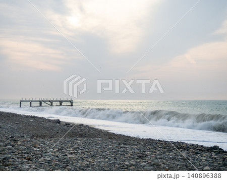 Destroyed pier under the waves. Bad weather at sea. Beautiful seashore with old architecture. Destroyed pier under the waves. Bad weather at sea. Beautiful seashore with old architecture. 140896388