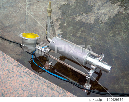Empty fountain in a city park. Dehumidification. Cleaning the fountain with a hose. The device of the fountain. Pipes for water supply. Water hoses. Modern technologies. 140896564