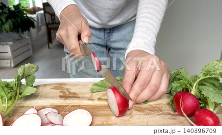 Hands slicing fresh red radishes Hands slicing fresh red radishes 140896709