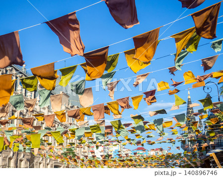 Flags over the street. City celebration concept. Warm colors. Scenery over the street. Flags over the street. City celebration concept. Warm colors. Scenery over the street. 140896746
