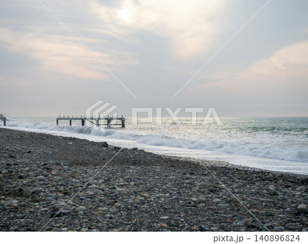 Destroyed pier under the waves. Bad weather at sea. Beautiful seashore with old architecture Destroyed pier under the waves. Bad weather at sea. Beautiful seashore with old architecture 140896824