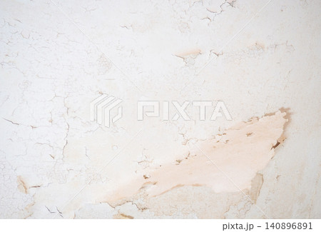 Ceiling of an old apartment. Crumbling plaster. The housing requires renovation. Background made of peel-off coating. Ceiling of an old apartment. Crumbling plaster. The housing requires renovation. Background made of peel-off coating. 140896891