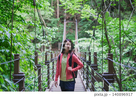 高尾山のつり橋を歩く笑顔の女性 高尾山のつり橋を歩く笑顔の女性 140896917