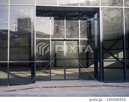 Empty glassed room for business. Premises for a car showroom. Abandoned place. Business decline concept. Empty glassed room for business. Premises for a car showroom. Abandoned place. Business decline concept. 140896958