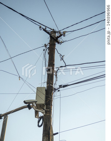 Old power line. New street camera on an old pole. Electricity supply to the population in Asia Old power line. New street camera on an old pole. Electricity supply to the population in Asia 140896966