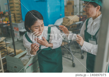バックヤードで体調不良の若い女性スタッフを助ける先輩スタッフ バックヤードで体調不良の若い女性スタッフを助ける先輩スタッフ 140897073