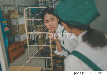 バックヤードで体の不調を先輩スタッフに訴える女性 バックヤードで体の不調を先輩スタッフに訴える女性 140897086