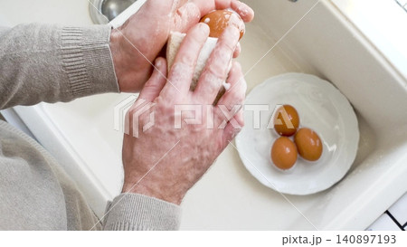 Man washes eggs with a sponge Man washes eggs with a sponge 140897193