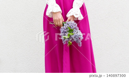 Cute woman holds a vibrant bouquet of lilacs Cute woman holds a vibrant bouquet of lilacs 140897300