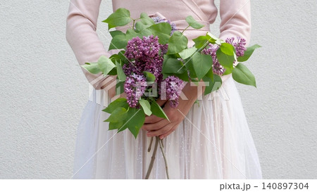 Cute woman holds a vibrant bouquet of lilacs Cute woman holds a vibrant bouquet of lilacs 140897304
