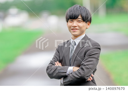 屋外で腕組みする若いビジネスマン 屋外で腕組みする若いビジネスマン 140897670