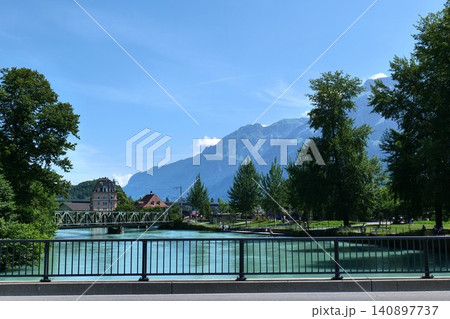 Scenic River with Turquoise Water, Bridge, and Alpine Mountains. switzerland 140897737