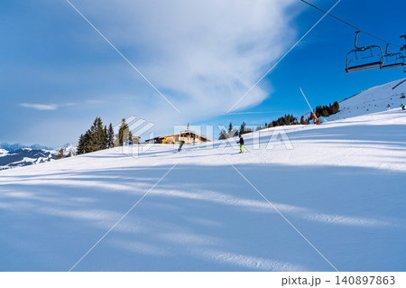 Skiers on a sunny slope at the Saalbach ski resort in the Austrian Alps during winter season Skiers on a sunny slope at the Saalbach ski resort in the Austrian Alps during winter season 140897863