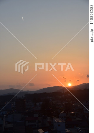 日本の岐阜県の高山市 市街地中心部の三重塔方面の町並み 美しい夕日と上空を飛行するジェット機 日本の岐阜県の高山市 市街地中心部の三重塔方面の町並み 美しい夕日と上空を飛行するジェット機 140898588