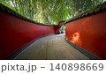 Traditional red wall path leading to bamboo garden 140898669