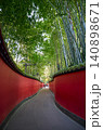 Traditional chinese red walls leading through bamboo forest 140898671