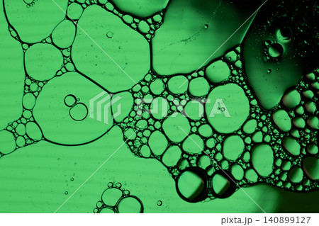 Close view of green fluid bubbles clustered in organic shapes, creating abstract cellular pattern with dark edges Close view of green fluid bubbles clustered in organic shapes, creating abstract cellular pattern with dark edges 140899127