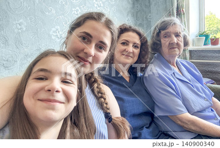 Four generations of women smiling together at home, family love and close connection Four generations of women smiling together at home, family love and close connection 140900340