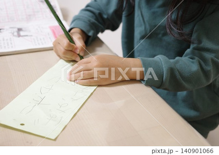 七夕の短冊に鉛筆で願い事を書く子どもの手 七夕の短冊に鉛筆で願い事を書く子どもの手 140901066