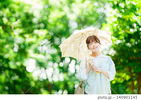 公園で日傘をさす女性 公園で日傘をさす女性 140901145