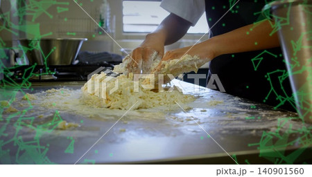 Kneading chef wearing white top and dark apron, pressing sticky dough on steel counter with flour Kneading chef wearing white top and dark apron, pressing sticky dough on steel counter with flour 140901560