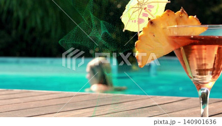 Showing cocktail glass sparkling on deck by pool, woman in swimsuit, pineapple wedge, copy space Showing cocktail glass sparkling on deck by pool, woman in swimsuit, pineapple wedge, copy space 140901636